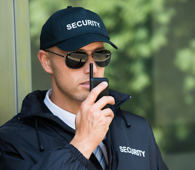 a security guard speaking on a walkie talkie