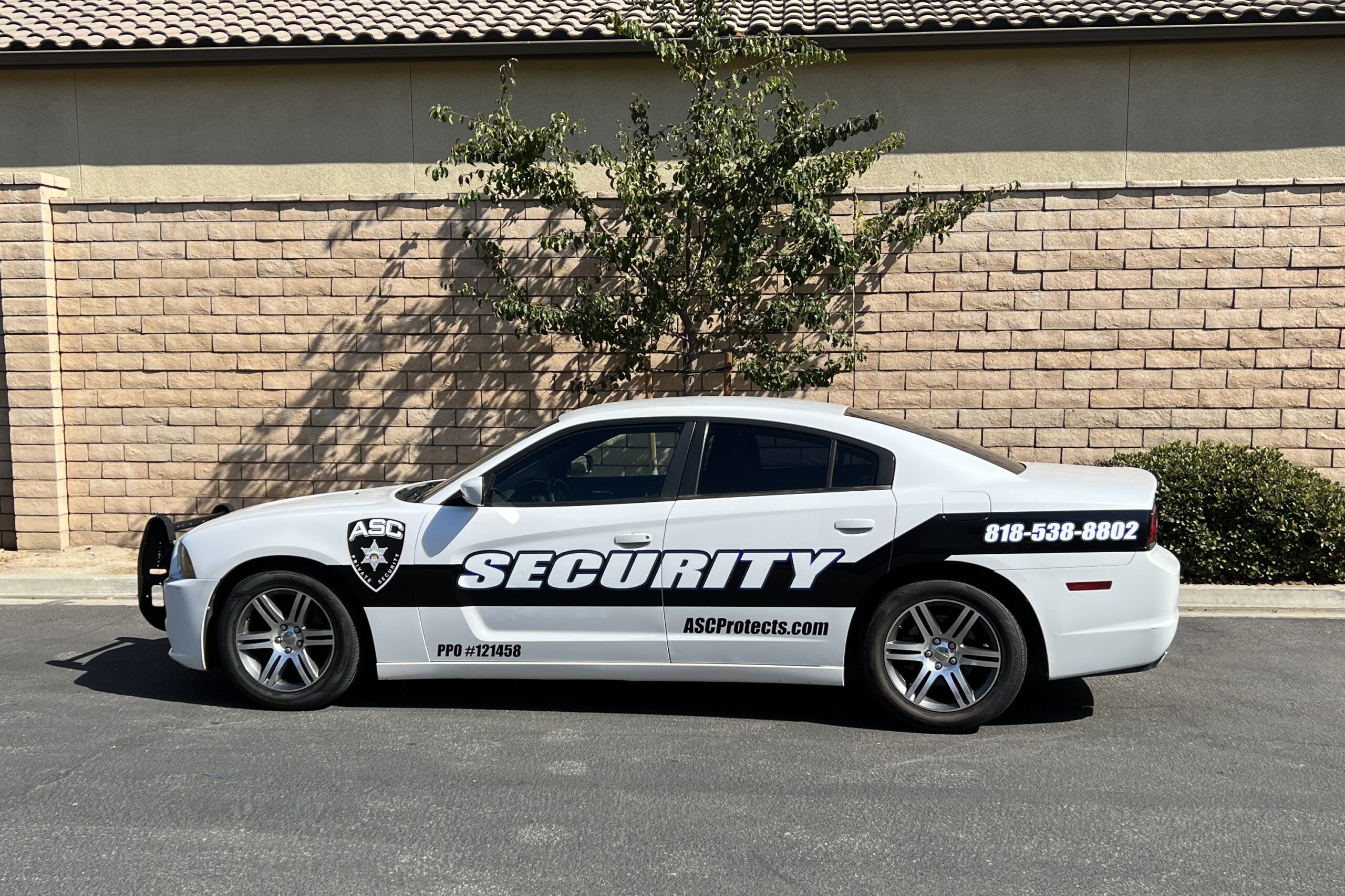 ASC Private Security mobile patrol car parked on the sidewalk